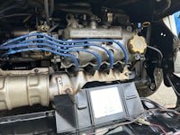 the engine of a car with blue wires attached to it